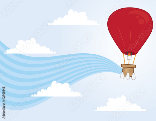 Hot air balloon floating through clouds in the sky