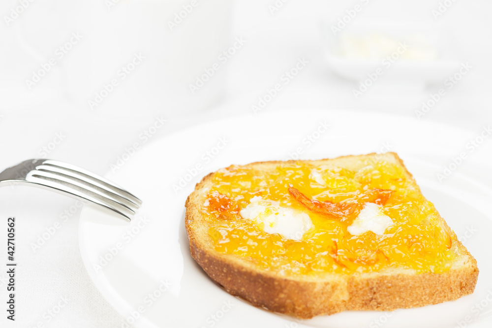 Breakfast. French toast, orange marmalade, butter, fork and whit