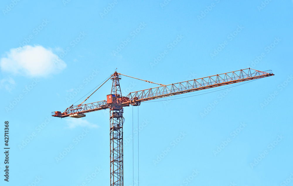 Red construction tower crane against blue sky Red construction tower crane against blue sky