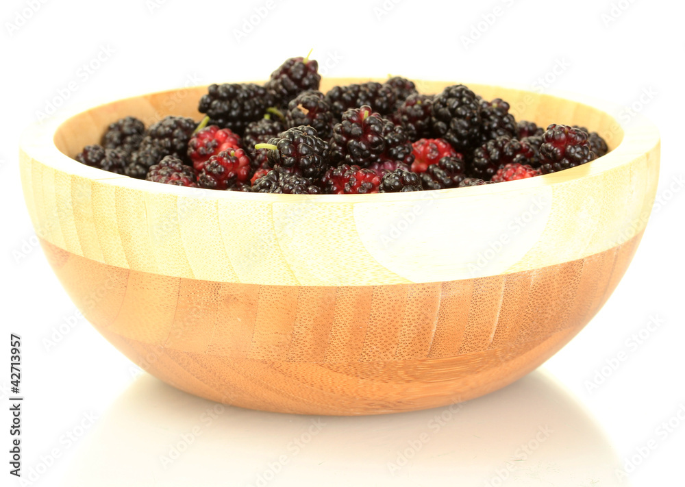 Wooden bowl with ripe mulberries isolated on white close-up Wooden bowl with ripe mulberries isolated on white close-up