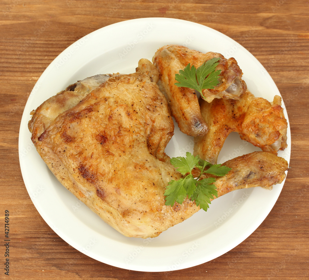 roasted chicken wings and leg with parsley in the plate roasted chicken wings and leg with parsley in the plate