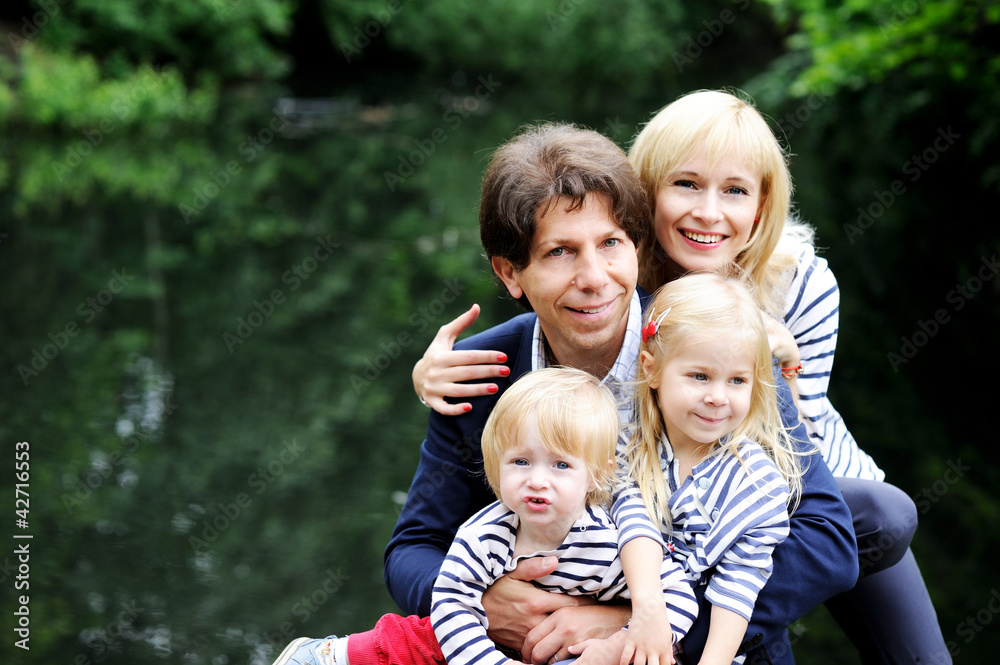 Naklejka premium Happy parents with children posing outdoors