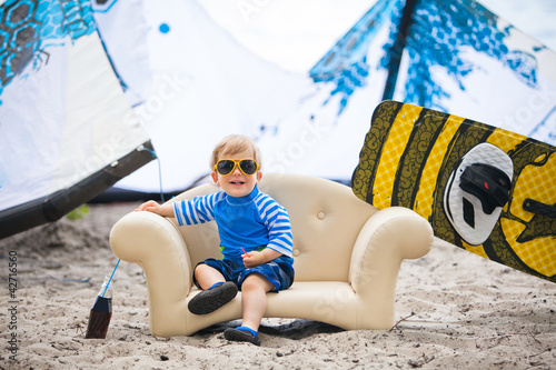 Adorable kiteboarder boy in the chair at the seaside