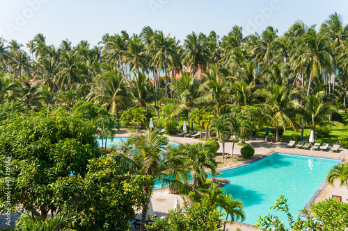 Beach hotel resort swimming pool surrounded by palm trees photo