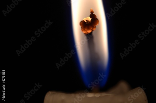 View of burning candlewick isolated over black photo