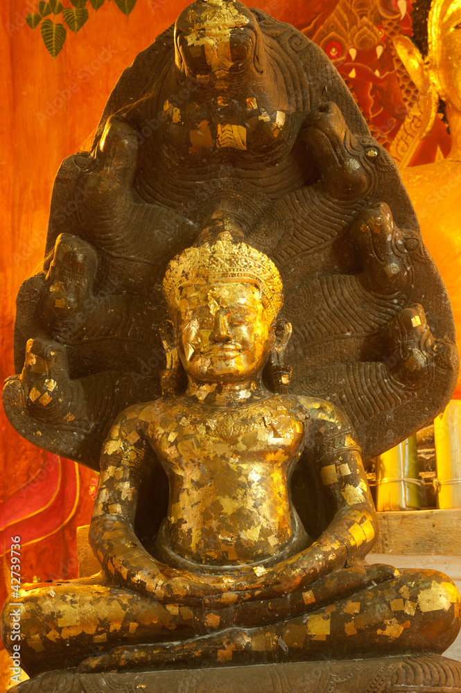 Ancient sitting Buddha in old temple in Thailand.