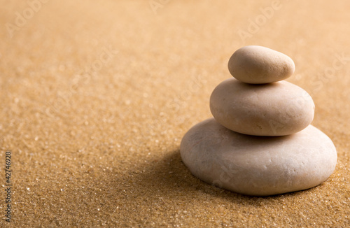 Three staked stones on sand