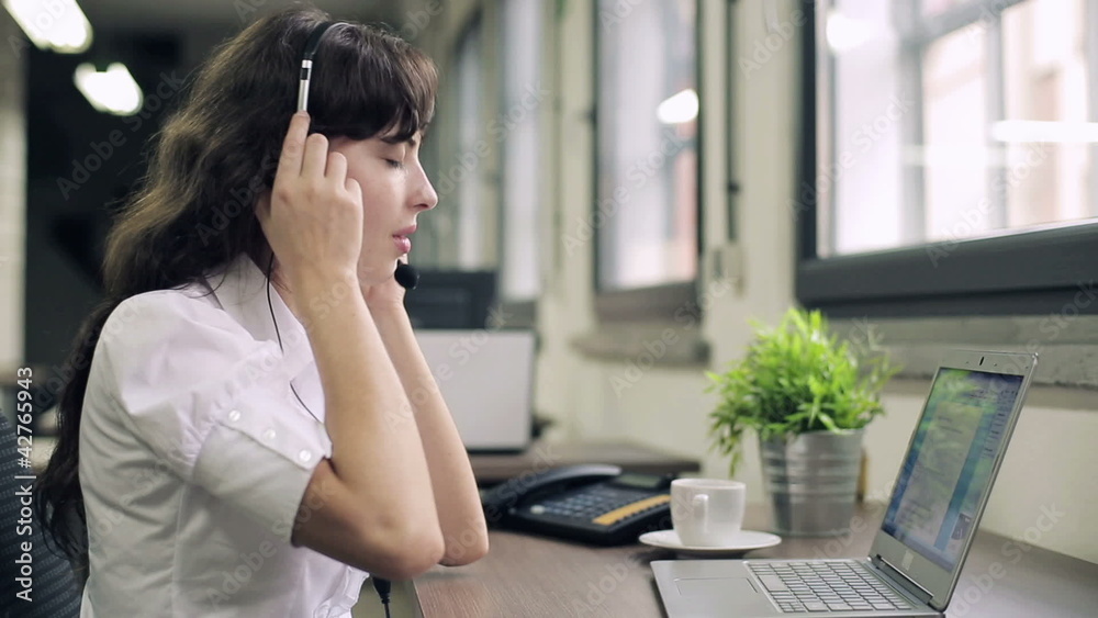 Tired, overworked female helpdesk consultant in the office Tired, overworked female helpdesk consultant in the office
