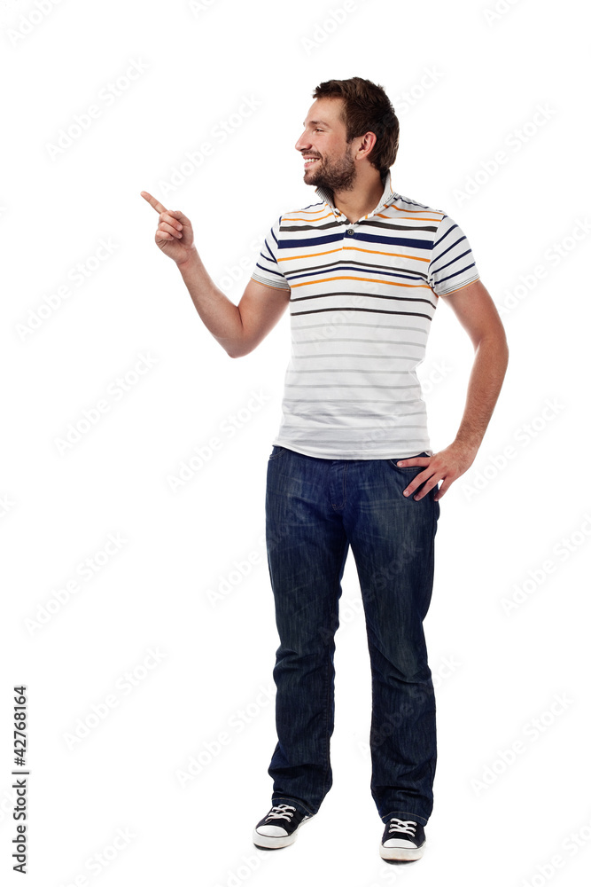 Young casual man pointing. Isolated