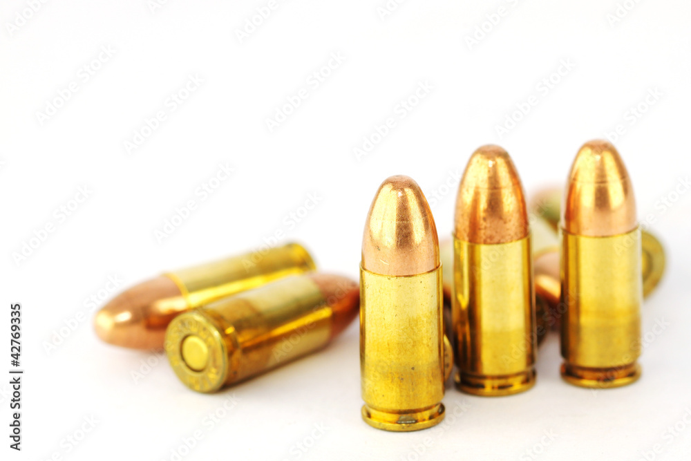 Live 9mm pistol round against white Live 9mm pistol round against white