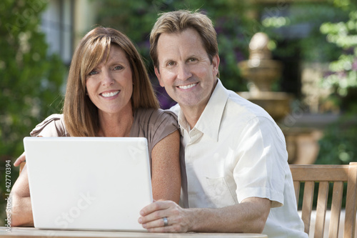 Man & Woman Couple Using Laptop Computer In Garden