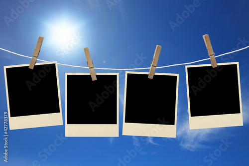 Photos frames hanging in the rope on a sky