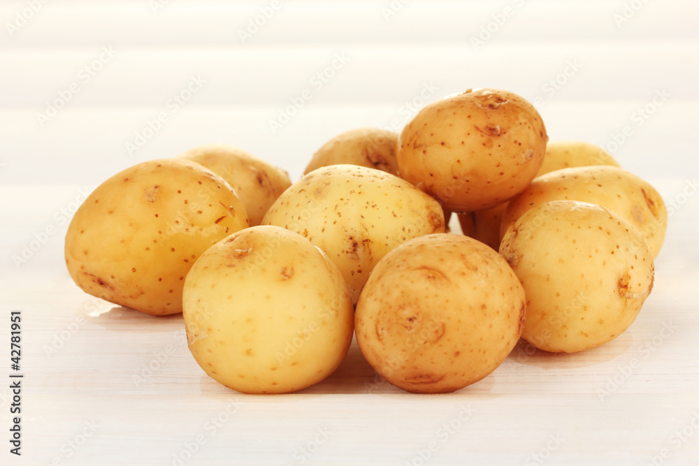 young potatoes on white wooden table close-up young potatoes on white wooden table close-up