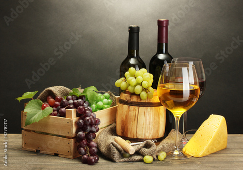barrel, bottles and glasses of wine, cheese and ripe grapes