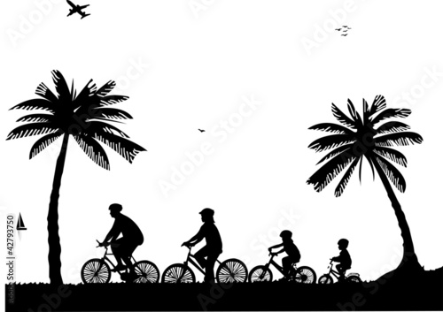 Family bike ride on the beach in summer silhouette