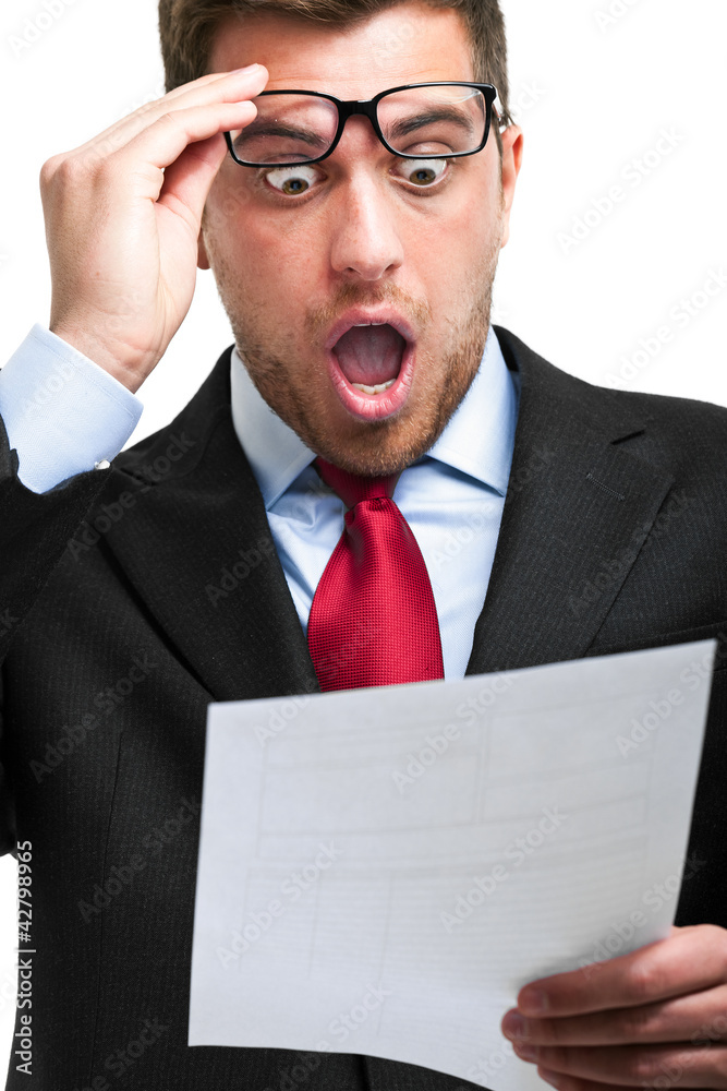 Shocked businessman while reading an expensive bill Shocked businessman while reading an expensive bill