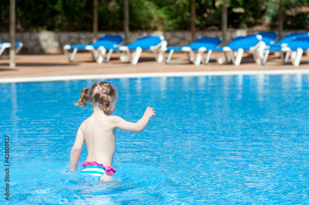 girl playing in the pool on holiday