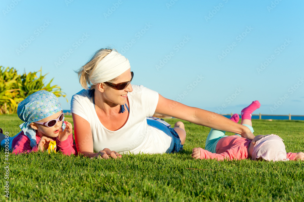 mother with two daughters playing on the grass