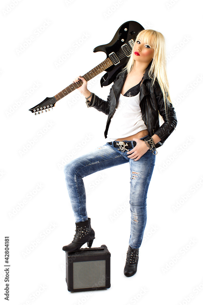 Sexy woman in blue jeans posing with black electric guitar