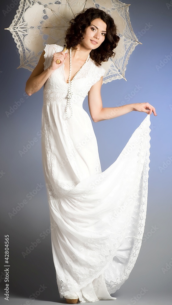 Young woman in retro bridal dress with umbrella on background. Young woman in retro bridal dress with umbrella on background.