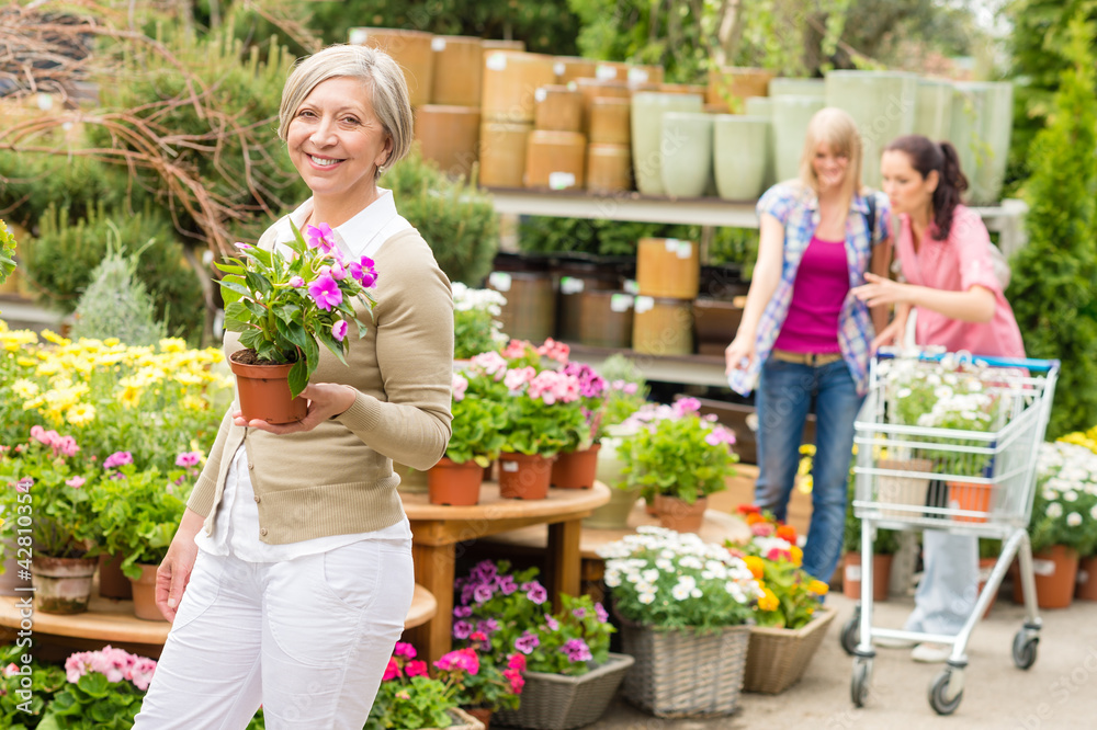 Garden center senior lady hold potted flower Garden center senior lady hold potted flower