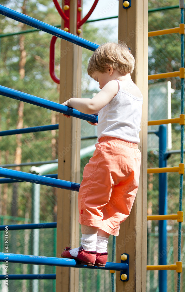 Active little child climbing on a high ladder Active little child climbing on a high ladder