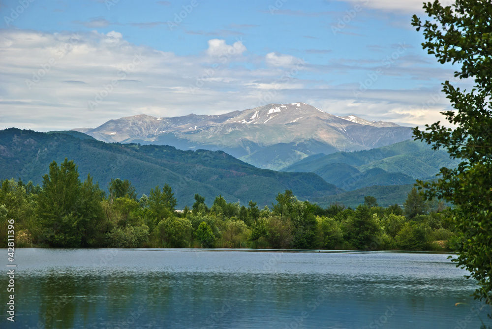 Summer landscape with lake, mountains, blue sky and clouds