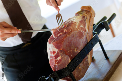 waiter slicing parma ham