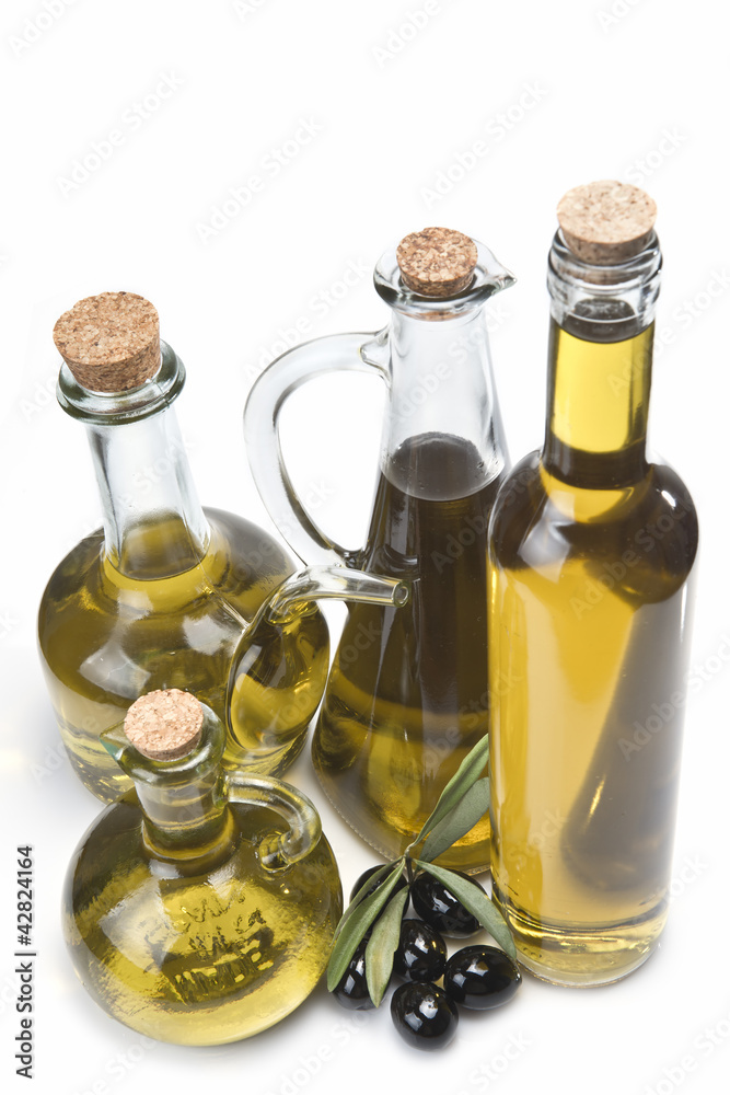 Botellas con aceite de oliva y aceitunas negras sobre blanco