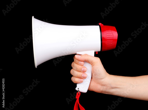 red and white megaphone in hand isolated on black