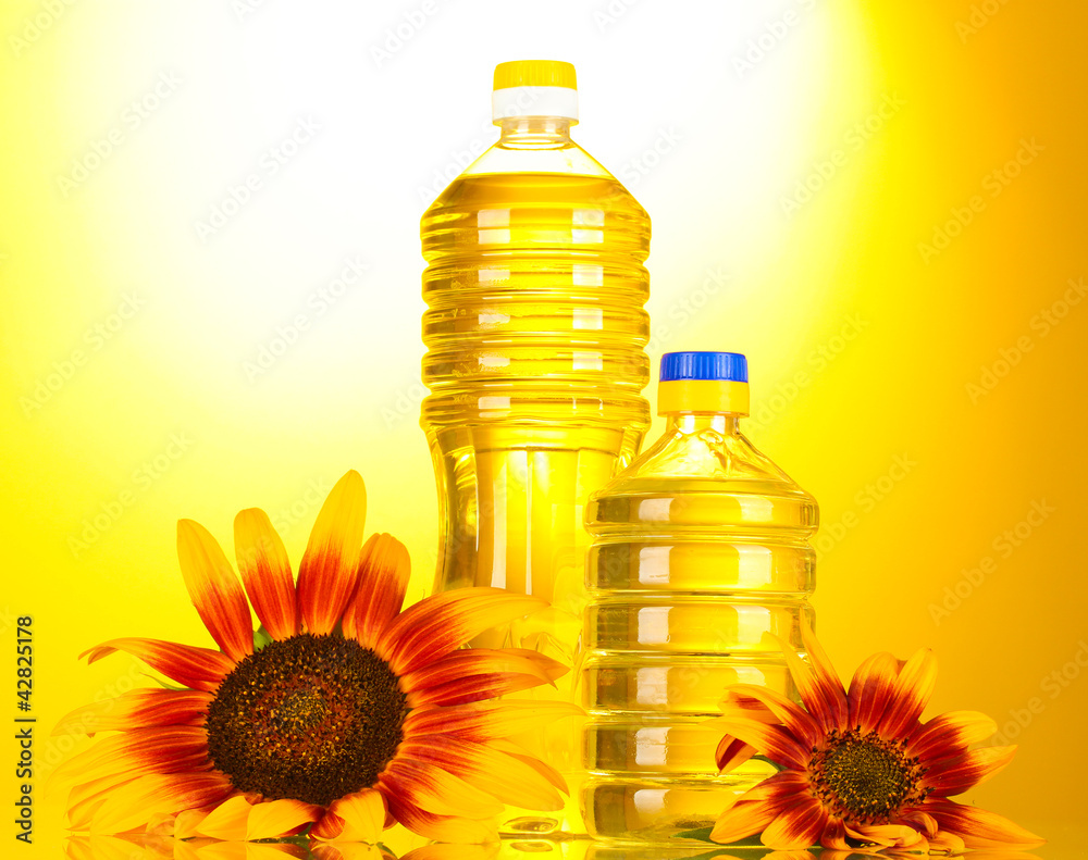 sunflower oil and sunflowers on yellow background. sunflower oil and sunflowers on yellow background.