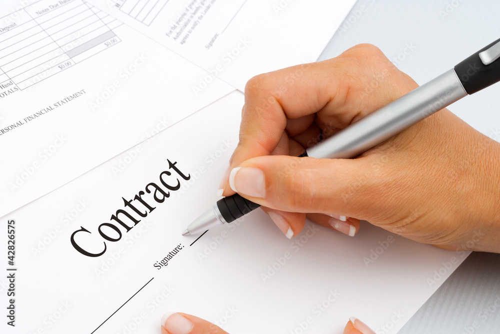 Close up of hand signing contract documents. Close up of hand signing contract documents.