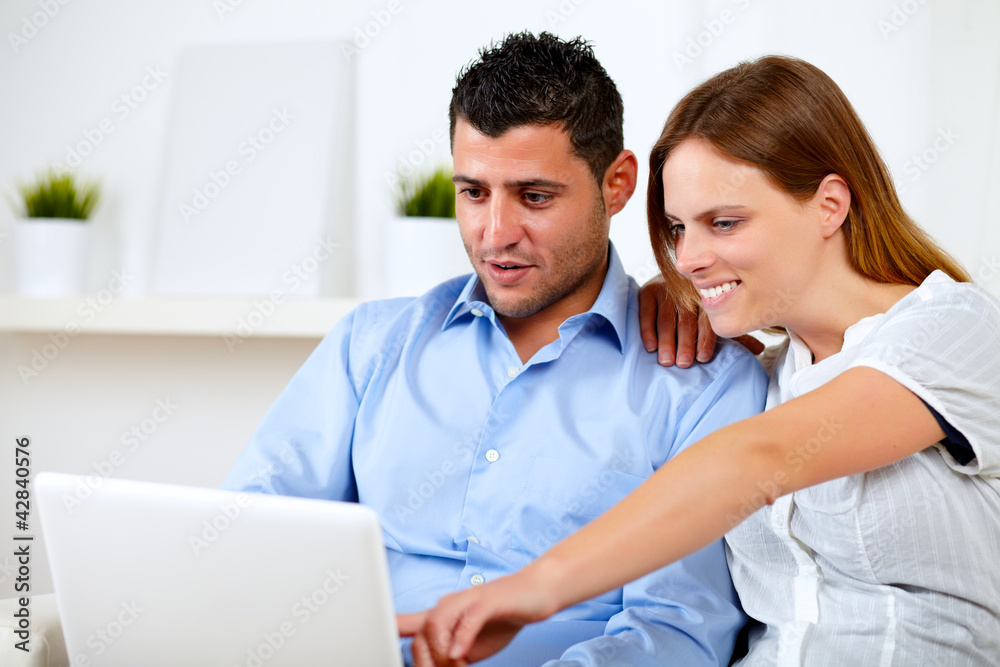 Fototapeta premium Charming young couple sitting on sofa