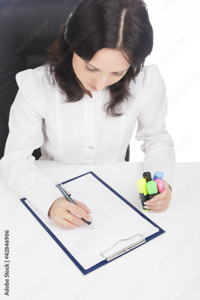 businesswoman wearing white writing on paper sheet while sitting businesswoman wearing white writing on paper sheet while sitting