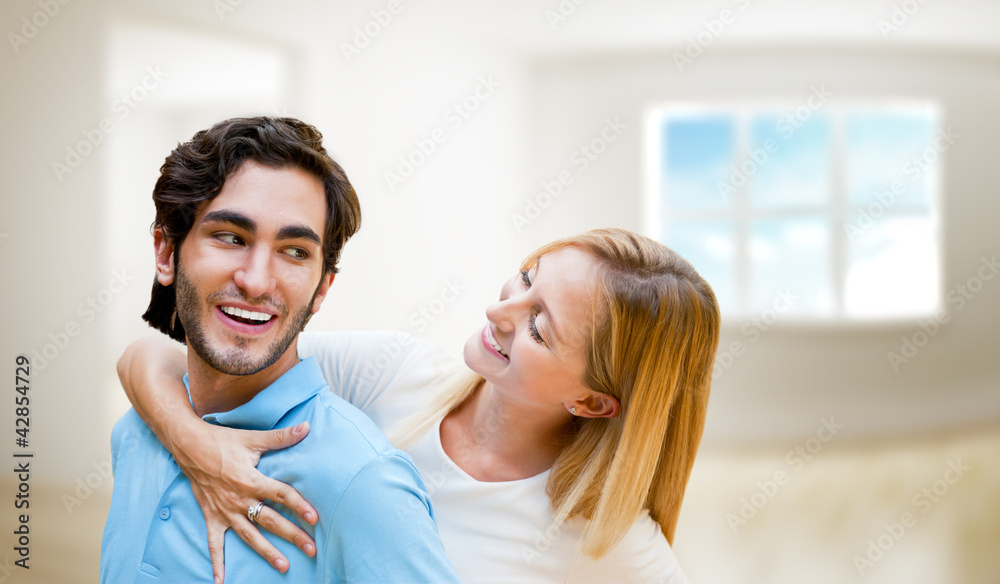 Cosy young couple embracing inside new apartment and planning to Cosy young couple embracing inside new apartment and planning to