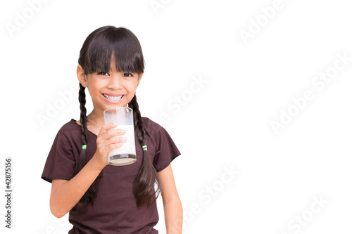 Smiling little girl with a glass of milk