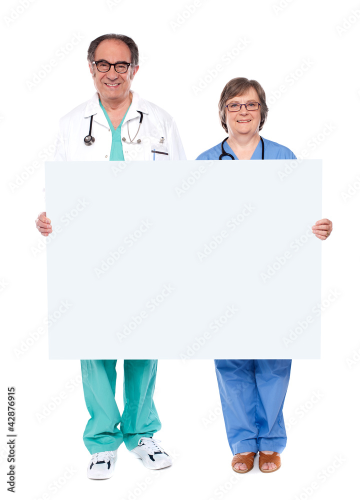 Medical professionals showing blank billboard Medical professionals showing blank billboard