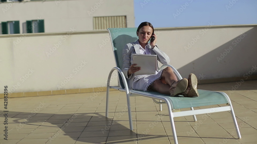 Businesswoman with cellphone and dokuments on sunbed, outdoor Businesswoman with cellphone and dokuments on sunbed, outdoor