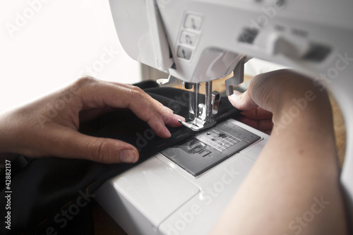 Dressmaker's hands and sewing machine