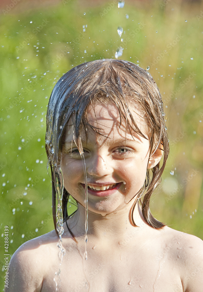 summer wet portrait of little girl playing with water Stock Photo