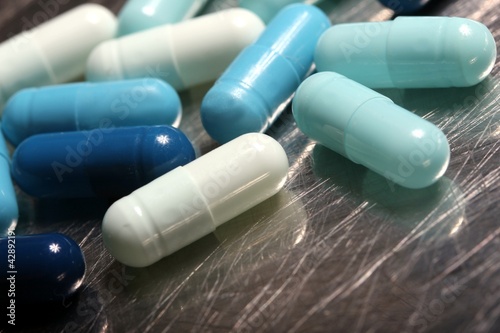 colored medicinical capsules on a steel plate photo