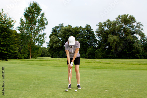 Frau spielt Golf auf einem Golfplatz © juniart