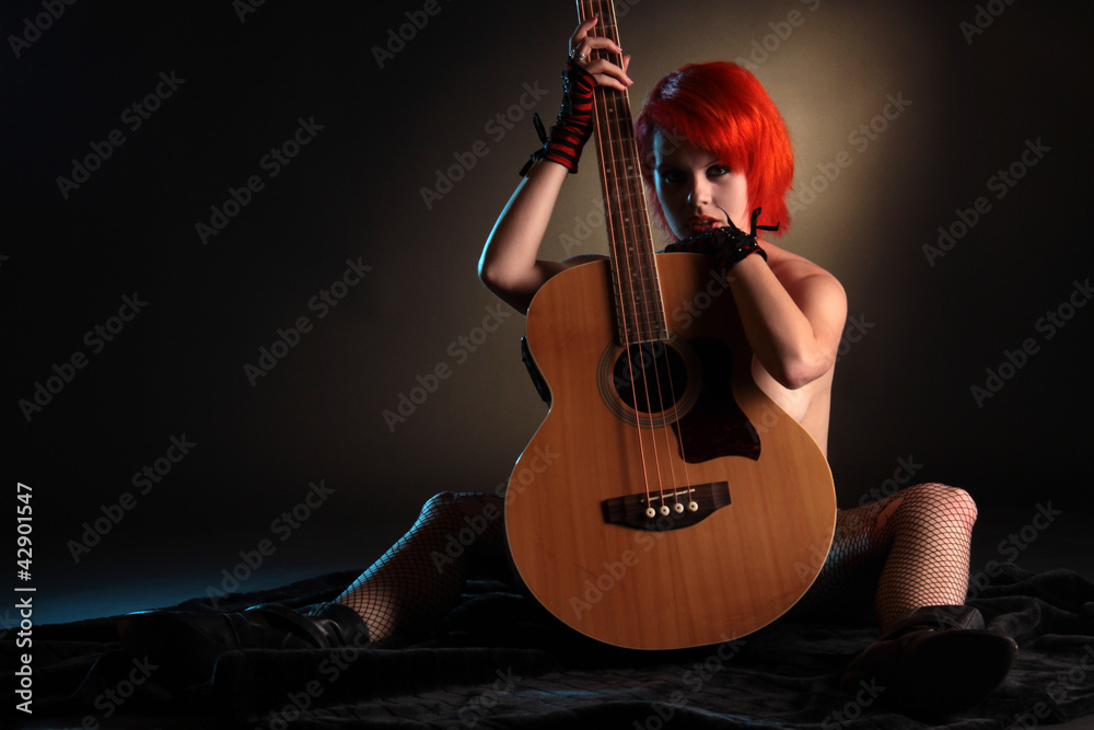Eine Frau sitzt nackt hinter Gitarre – Stock-Foto | Adobe Stock