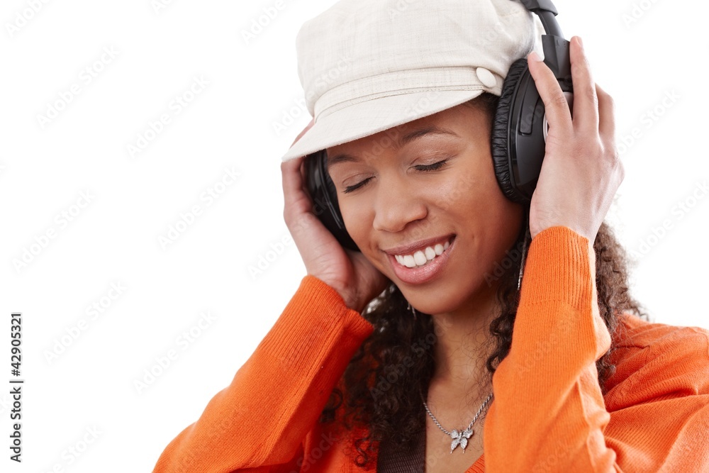 Happy woman enjoying music through earphones Happy woman enjoying music through earphones