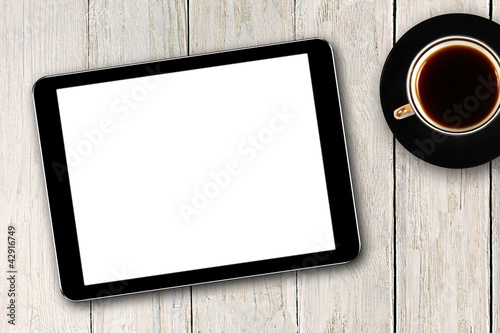 digital tablet and coffee cup on wooden table