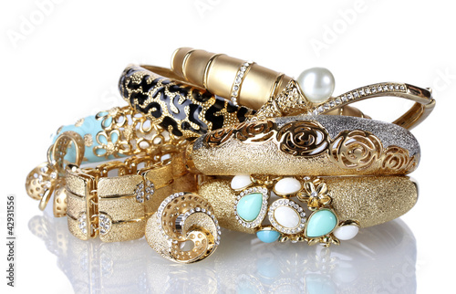 Beautiful golden bracelets and rings isolated on white