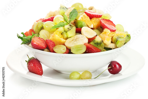 bowl with fresh fruits salad and berries isolated on white