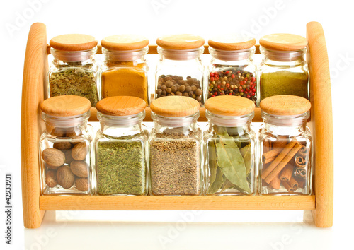 powder spices in glass jars on wooden shelf isolated on white