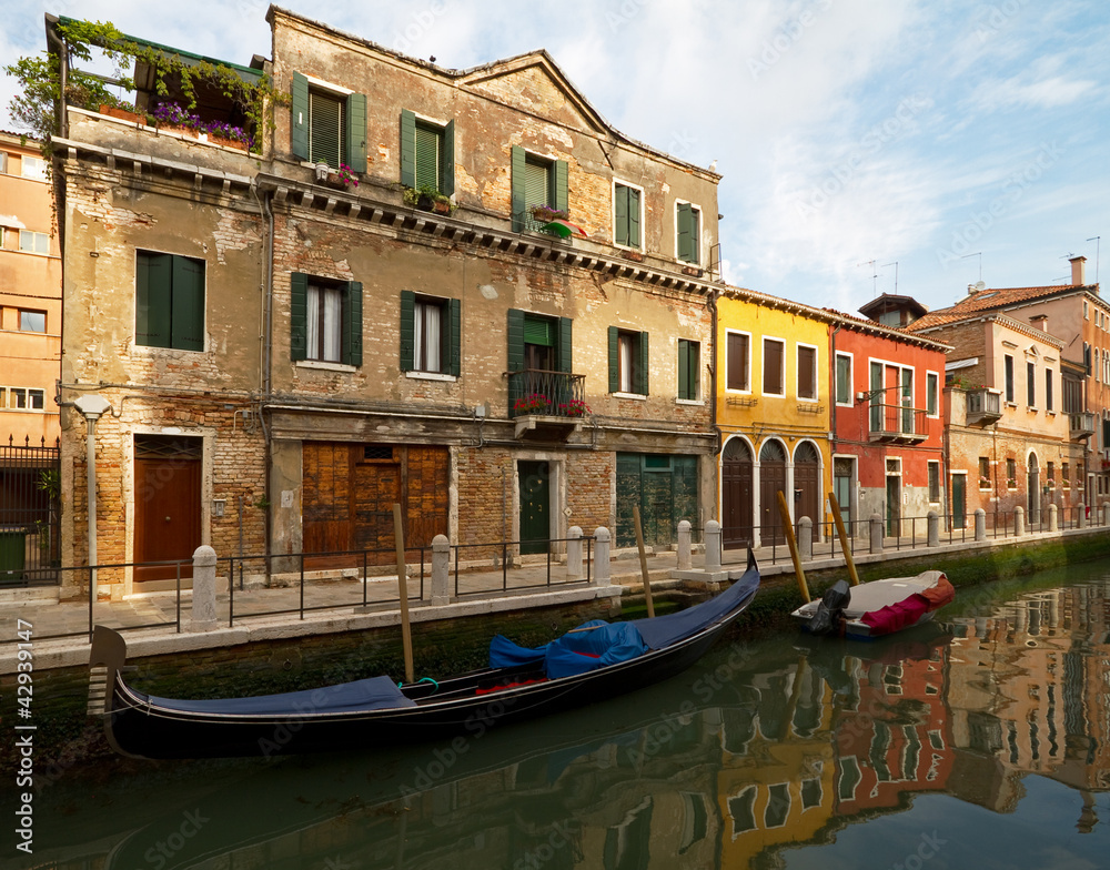 Canal with gondola on the island Murano, near Venice.