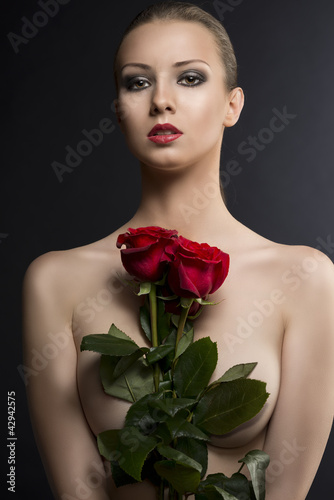 gilr's low key portrait with roses in the center of her chest
